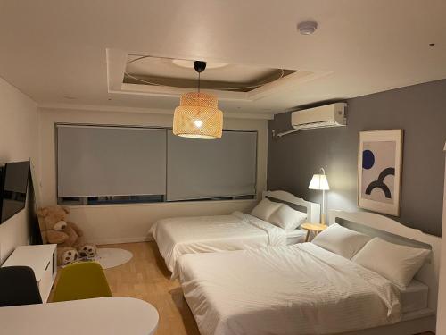 a bedroom with two beds and a large window at WinSome_HongDae in Seoul