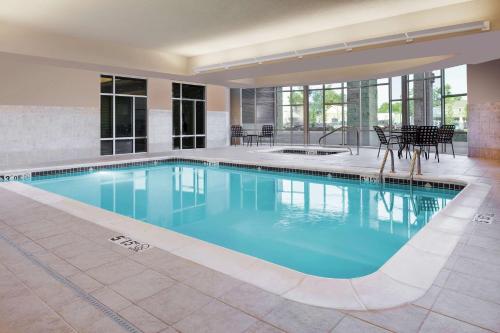 a swimming pool with blue water in a building at Hilton Garden Inn Manhattan Kansas in Manhattan