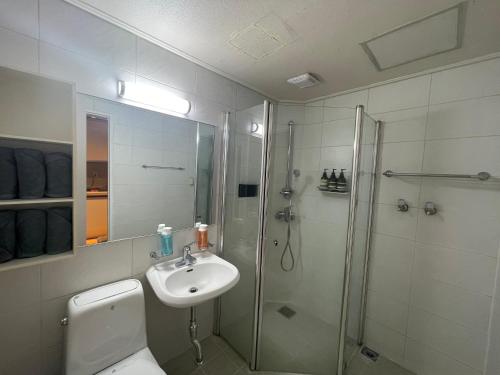 uma casa de banho com um WC, um chuveiro e um lavatório. em WinSome_HongDae em Seul