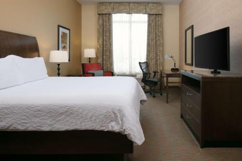 a hotel room with a bed and a television at Hilton Garden Inn Manhattan Kansas in Manhattan