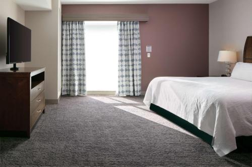 a bedroom with a bed and a large window at Hilton Garden Inn Manhattan Kansas in Manhattan