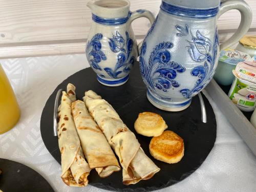 a plate of food on a table with blue and white vases at Maison écologique de qualité supérieure in Monflanquin