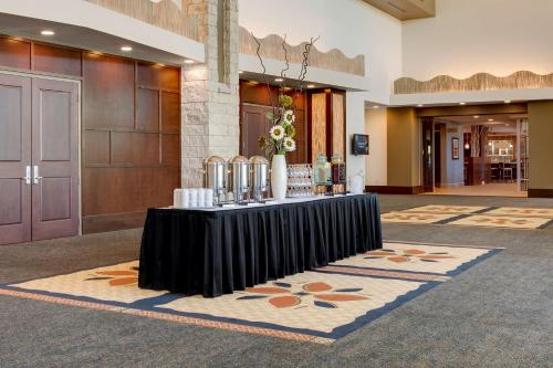 a lobby with a black table with flowers on it at Hilton Garden Inn Manhattan Kansas in Manhattan