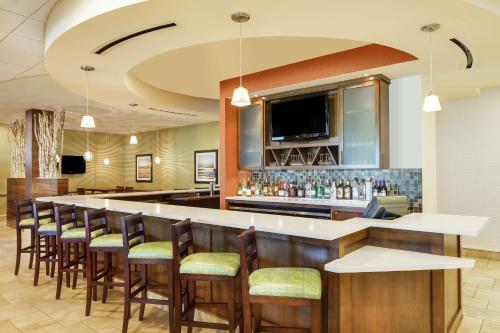 a bar in a restaurant with a row of bar stools at Hilton Garden Inn Manhattan Kansas in Manhattan