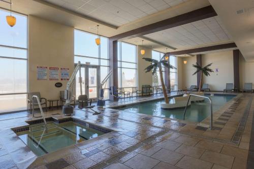 a swimming pool in a large building with windows at DoubleTree by Hilton Bay City - Riverfront in Bay City
