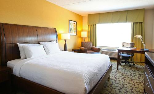 a hotel room with a large bed and a desk at Hilton Garden Inn Olathe in Olathe