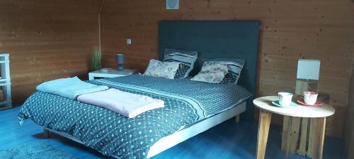 um quarto com uma cama com uma almofada para cães e uma mesa em Les hortensias de Stéfanick em Mûr-de-Bretagne