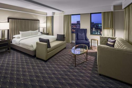 une chambre d'hôtel avec un lit, un canapé et une chaise dans l'établissement Hilton President Kansas City, à Kansas City
