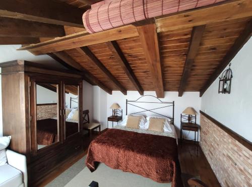 1 dormitorio con cama grande y techo de madera en Saika Rural, en Manjirón