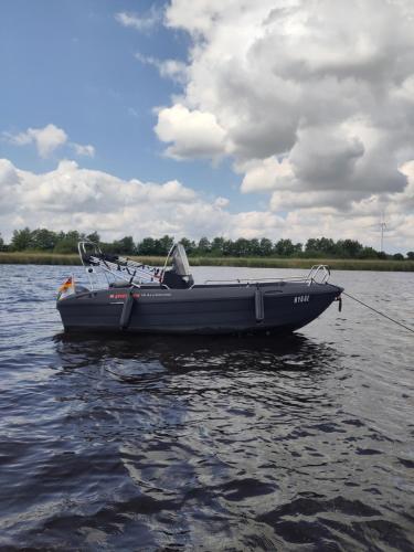 a black boat on a body of water at Ferienhaus Am Fehntjer Tief in Emden