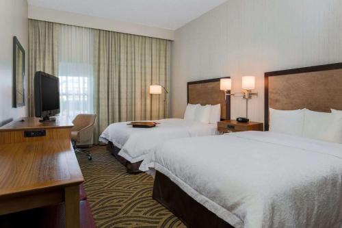 a hotel room with two beds and a flat screen tv at Hampton Inn Memphis-Southwind in Memphis