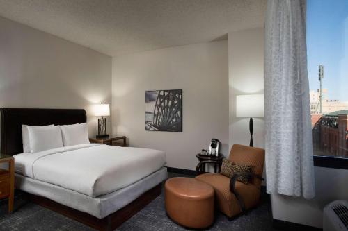 ein Hotelzimmer mit einem Bett und einem Stuhl in der Unterkunft DoubleTree by Hilton Memphis Downtown in Memphis