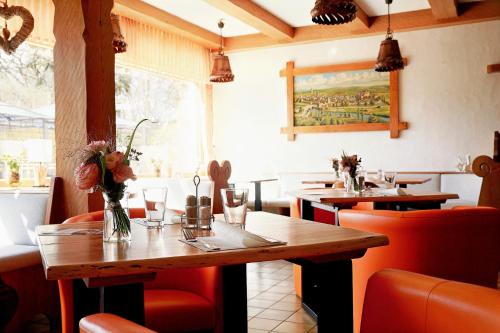 a restaurant with wooden tables and red chairs at Hotel Bergschlößchen in Simmern