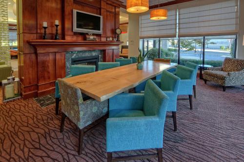 a dining room with a wooden table and blue chairs at Hilton Garden Inn Memphis/Southaven in Southhaven