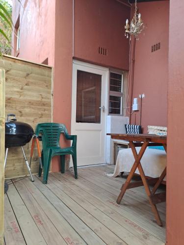 a patio with a table and a green chair at Ocean Walk Penguin in Zinkwazi Beach