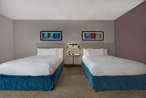 a hotel room with two beds and two windows at Hilton Garden Inn Memphis/Southaven in Southhaven