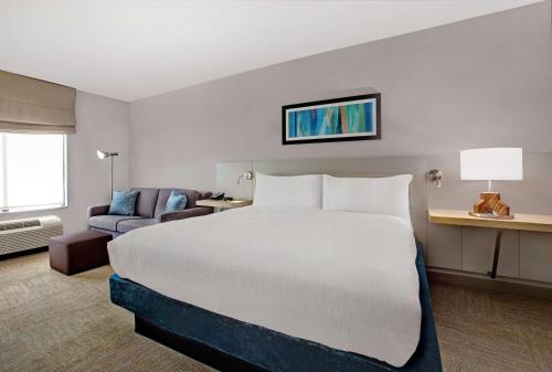 a hotel room with a large bed and a couch at Hilton Garden Inn Memphis/Southaven in Southhaven