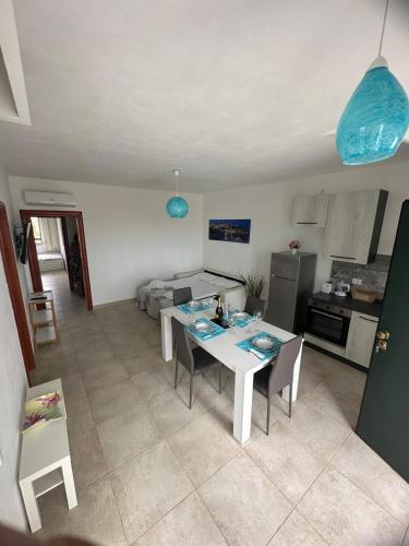 a kitchen and living room with a table and chairs at Casa Leukos Salento - con terrazza privata in Vignacastrisi