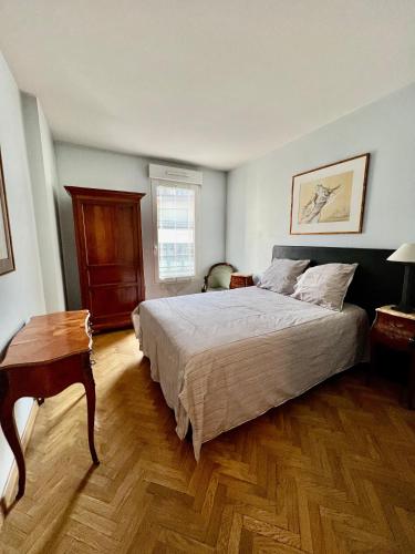 une chambre avec un grand lit et un parquet dans l'établissement Appartement Chevaleret, à Paris