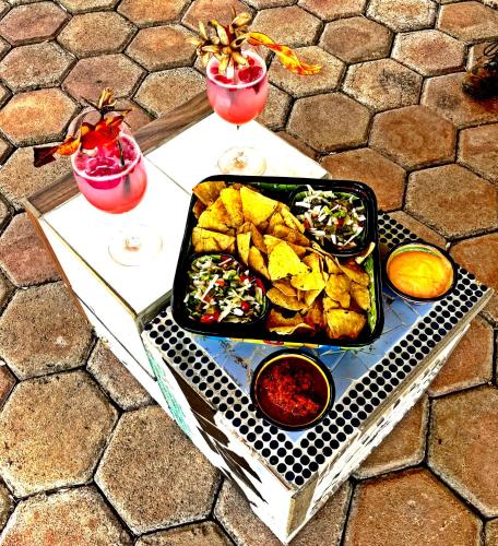 un tavolo con un vassoio di cibo e due bevande di GREEN PARADISE LEONA VICARIO a Leona Vicario