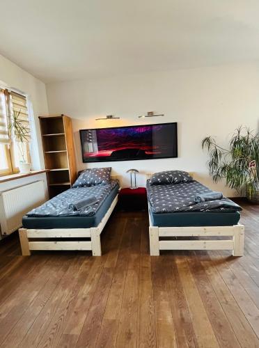 a room with two beds and a tv on the wall at Warszawa Bemowo Pokoje in Warsaw