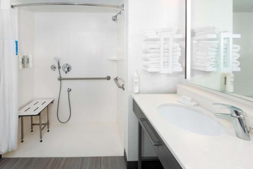 a white bathroom with a shower and a sink at Hampton Inn & Suites Country Club Plaza in Kansas City