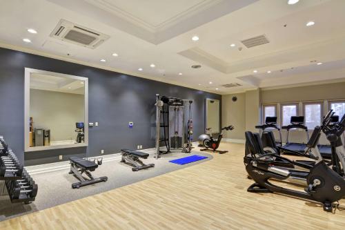 a gym with treadmills elliptical machines and a mirror at Embassy Suites by Hilton Milpitas Silicon Valley in Milpitas