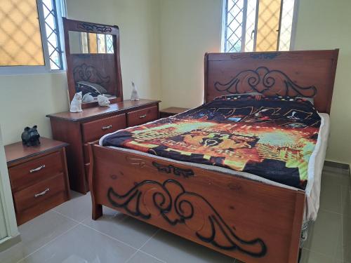 ein Schlafzimmer mit einem großen Holzbett und zwei Kommoden in der Unterkunft Casa de Marilyn in Andrés