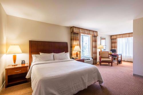 una camera d'albergo con letto e scrivania di Hilton Garden Inn Milwaukee Northwest Conference Center a Milwaukee