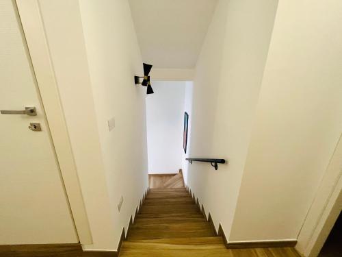a hallway with white walls and wooden floors at MAVÌ in Leverano