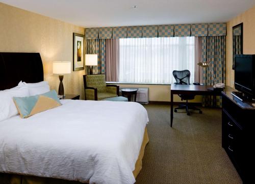 a hotel room with a bed and a desk and a television at Hilton Garden Inn Mankato Downtown in Mankato