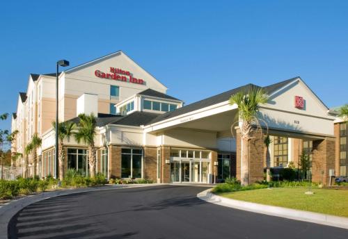 a front view of a hotel with palm trees at Hilton Garden Inn Mobile West I-65 Airport Boulevard in Mobile