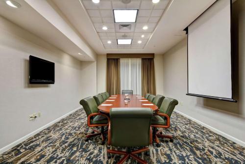 a conference room with a table and chairs and a screen at Hilton Garden Inn Mobile East Bay / Daphne in Daphne