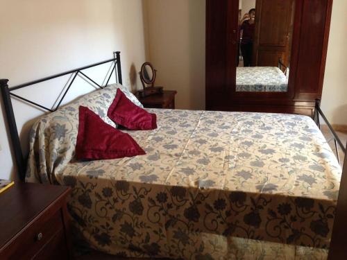 1 dormitorio con 1 cama con 2 almohadas rojas en LA CASA DEI POETI - C.I.R. 054039LOTUR19934, en Perugia