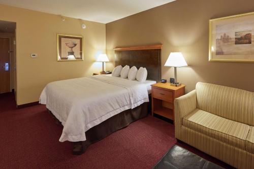 Habitación de hotel con cama y silla en Hampton Inn Massillon, en Massillon