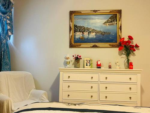 Un dormitorio con un tocador con una pintura en la pared en Four Seasons Private Villa en Powell River