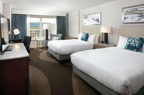 a hotel room with two beds and a desk at Hilton Madison Monona Terrace in Madison