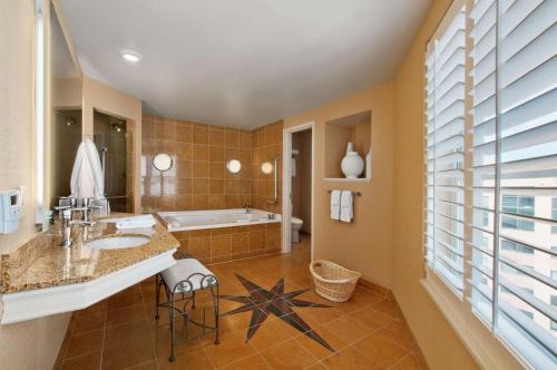 a bathroom with a sink and a bath tub at Hilton Madison Monona Terrace in Madison