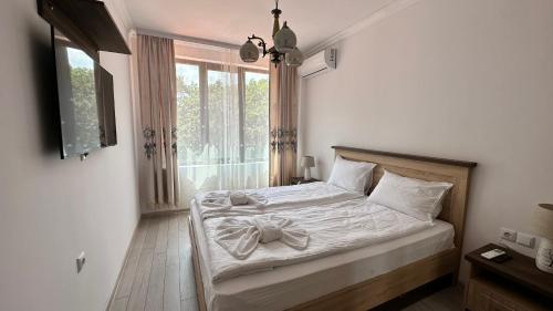 a bedroom with a bed and a window at Green Paradise Complex in Primorsko