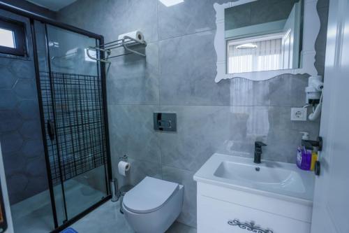 y baño con aseo, lavabo y ducha. en Zümrüt Villaları, en Sapanca