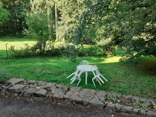 uma mesa branca sentada na relva num quintal em Les chênes blancs em Aubin