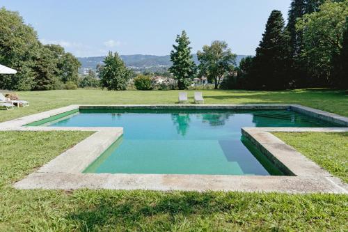 a swimming pool in the middle of a field at Cottage São Veríssimo in Figueiredo