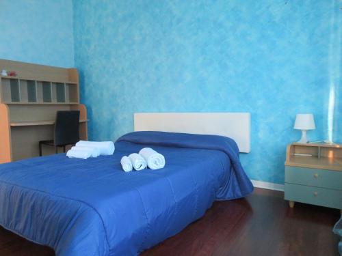 una camera blu con un letto e due asciugamani laminati di Villetta Camastra a Misterbianco