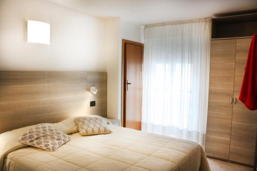 a bedroom with a bed and a window at Hotel Daniela in Rimini
