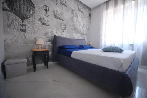 1 dormitorio con cama con sábanas azules y ventana en Luxury B&B Charlemagne, en Salerno