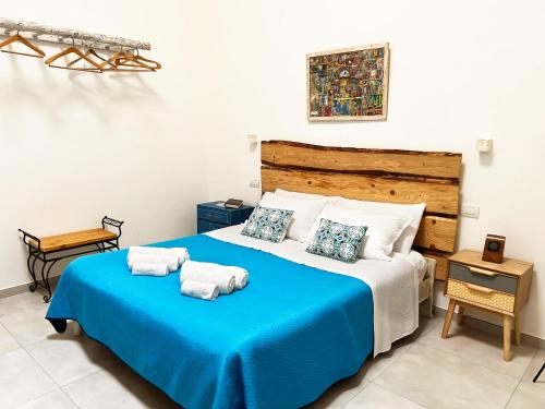Un dormitorio con una cama azul con toallas. en TornaRé, en Trani