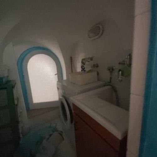 een kleine badkamer met een wastafel en een raam bij Casa della Nonna in Atrani
