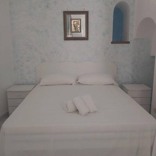 een wit bed met twee kussens erop bij Casa della Nonna in Atrani