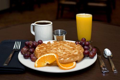 a plate of pancakes and grapes and a glass of orange juice at Hilton Garden Inn New York/Manhattan-Chelsea in New York