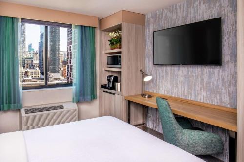a hotel room with a bed and a television at Hilton Garden Inn New York/Manhattan-Chelsea in New York